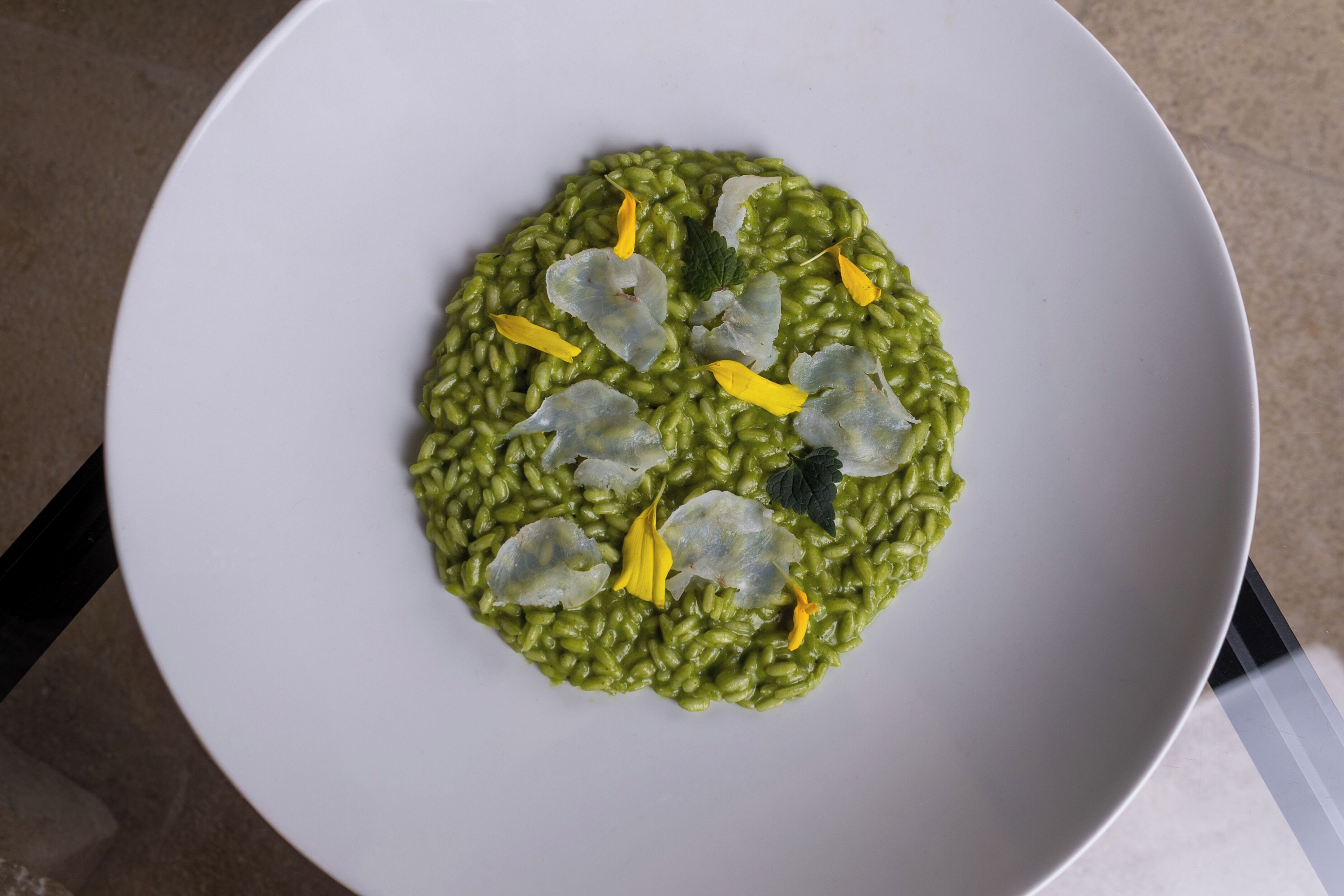 Un plato de risotto verde con guarniciones.