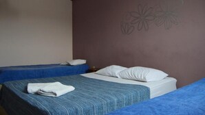 A room with two beds, one with a blue bedspread and the other with a white bedspread. There is a wall decoration of flowers above the beds. - Hotel 50 (Extrema)