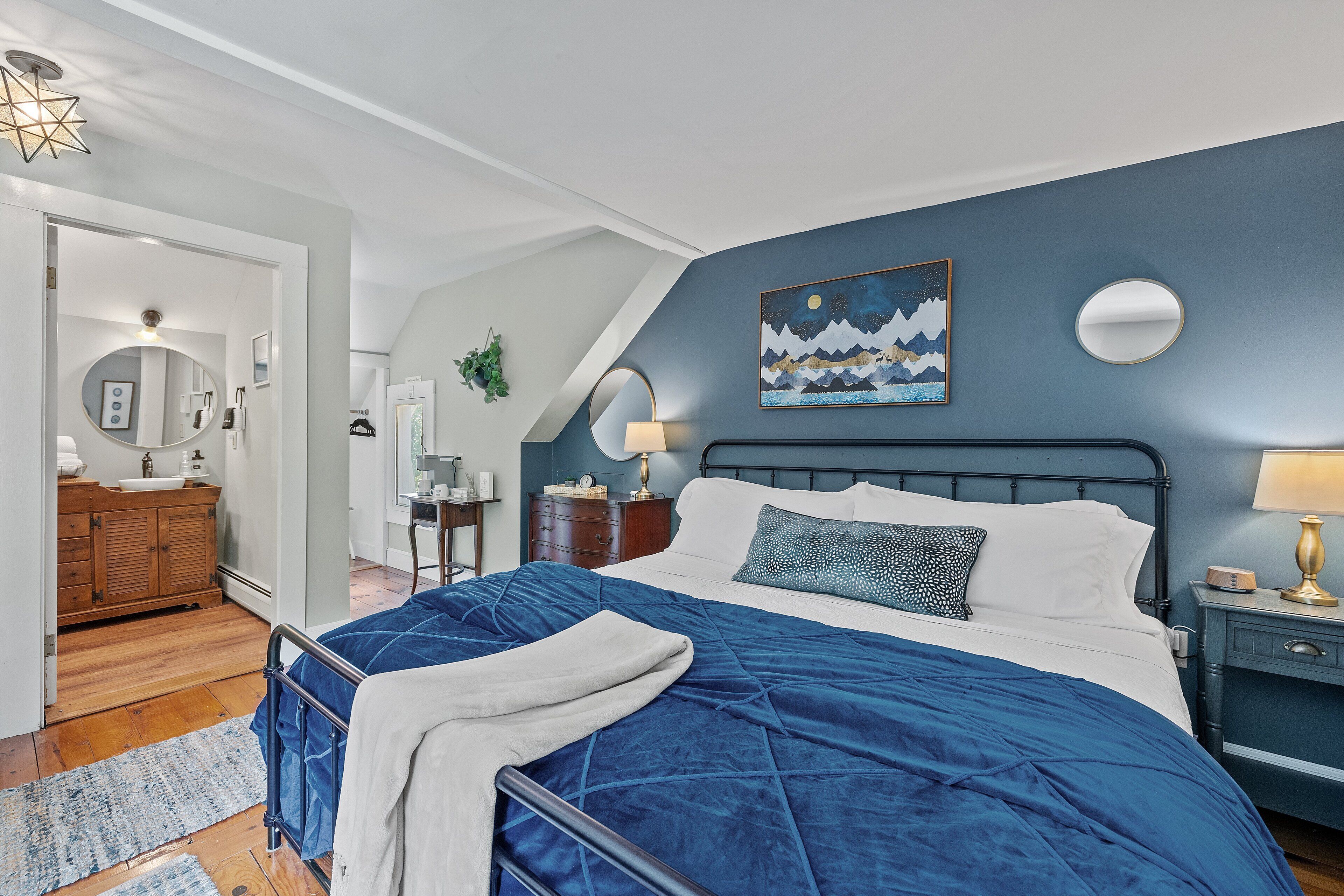 Een slaapkamer met een bed, nachtkastje en een klein tafeltje.