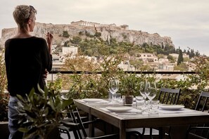 Mesa lista para comer con vistas a unas ruinas antiguas al fondo.