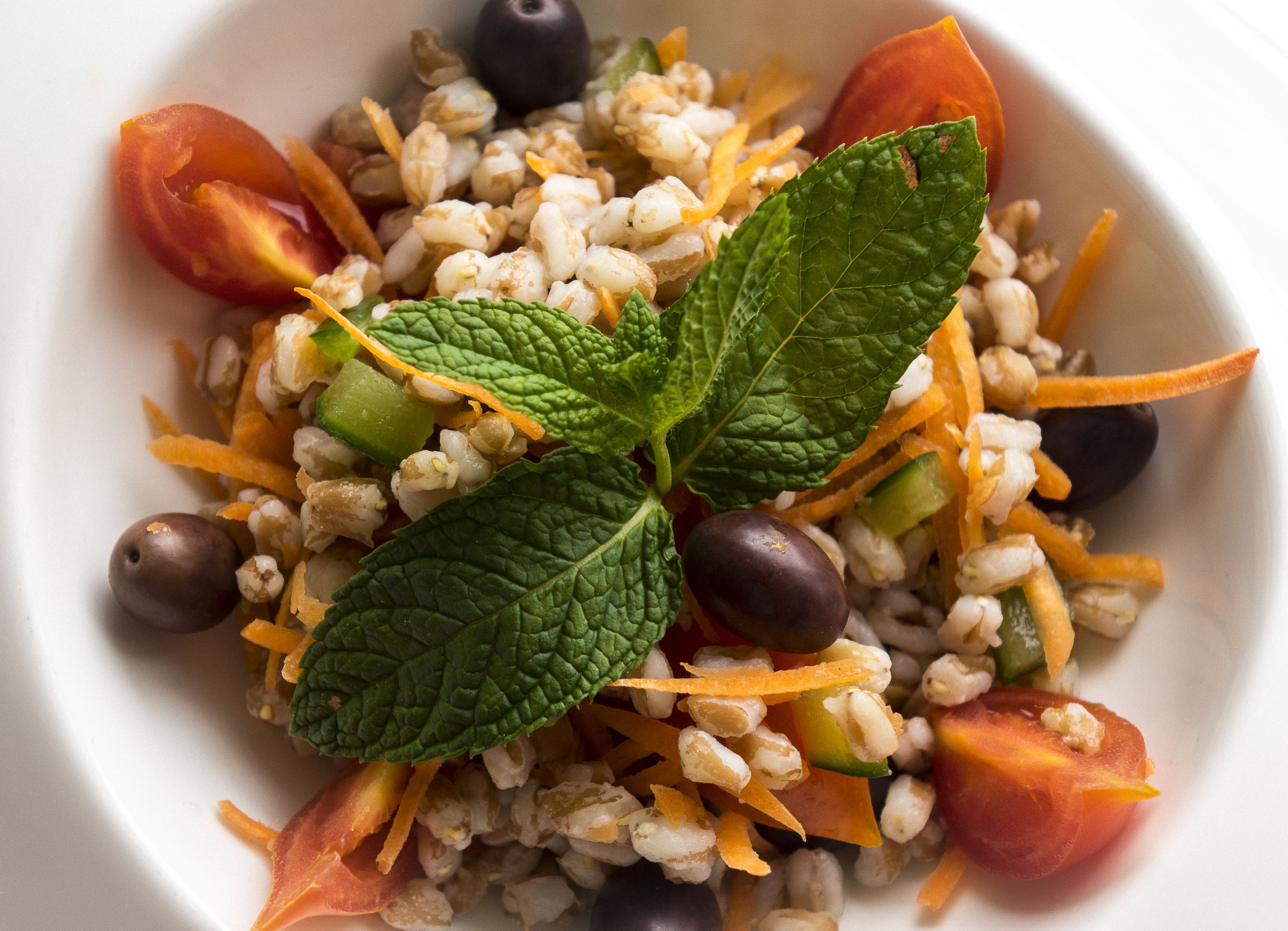 A bowl of salad with various vegetables and nuts.