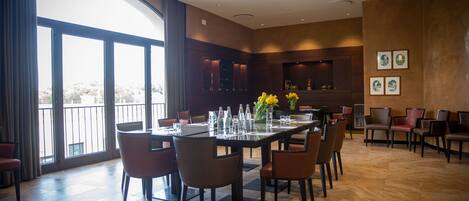 A spacious dining area with a large table set for six, surrounded by chairs.