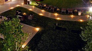 A modern hotel with a courtyard, outdoor seating, and a pool area. - Acaya Golf Resort & SPA (Vernole)