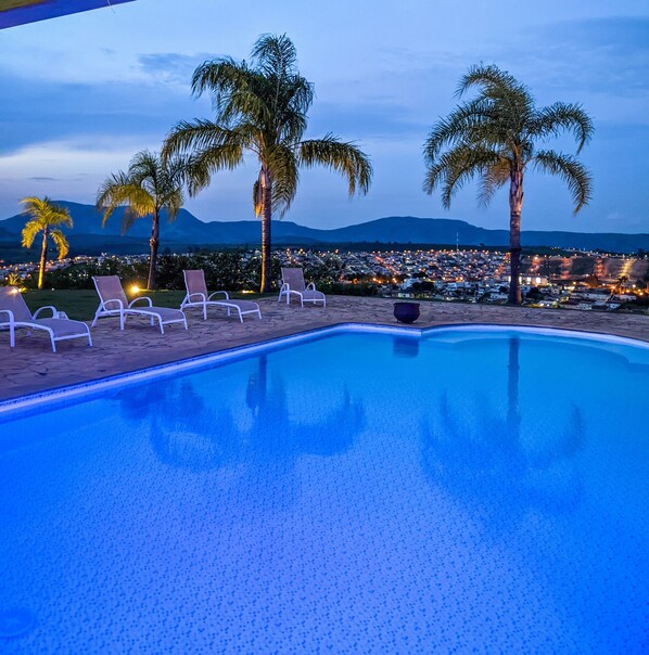 Alberca al aire libre y camastros 