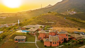 A residential area with houses featuring tiled roofs and a swimming pool. - Hotel Varandas da Montanha (Carmo do Rio Claro)