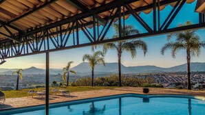 A pool area with a view of mountains and a cityscape. - Hotel Varandas da Montanha (Carmo do Rio Claro)
