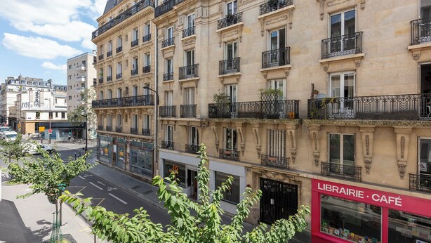 Un immeuble à plusieurs étages abritant un café et une bibliothèque au rez-de-chaussée.