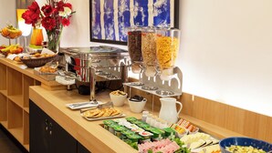 Un buffet proposant une variété d’aliments, notamment des fruits, des légumes, de la viande et des produits laitiers.