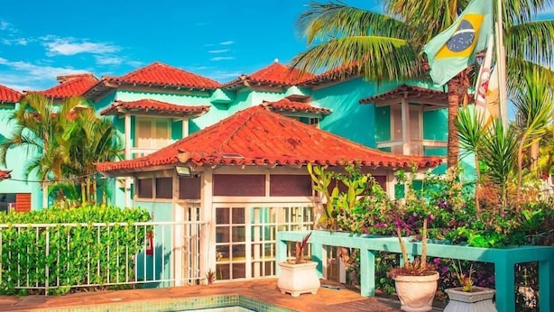 Um hotel com vários edifícios, piscina e vegetação exuberante.