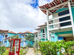 A hotel with multiple-story buildings, a red telephone booth, and a well-maintained garden with pathways.