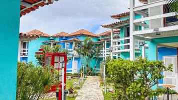 Uma trilha leva a um edifício com telhado ladrilhado e fachada azul.