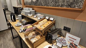 A breakfast buffet with various food items and condiments. - Hotel Bariloche By Tierra Gaucha (San Carlos de Bariloche)
