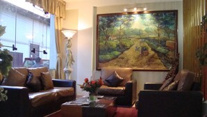 Un salón con un conjunto de sofás, una mesa de centro y un cuadro en la pared.