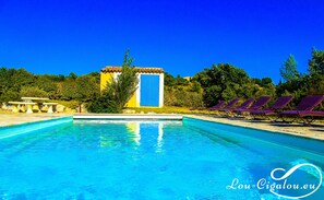 Una piscina al aire libre de temporada, sombrillas