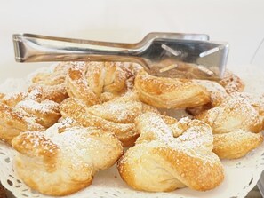 A tray of pastries dusted with powdered sugar. - Hotel Dante (Jesolo)