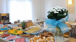 A buffet table with various food items and a bouquet of flowers. - Hotel Dante (Jesolo)