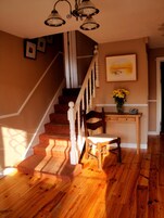 A staircase with wooden steps and white balusters, leading to a landing with a desk and chair.
