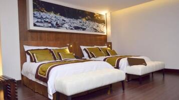 A hotel room with two beds, wooden headboards, and a large framed picture on the wall.