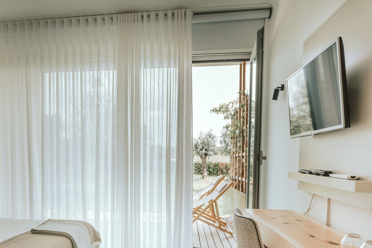 Een hotelkamer met een bed, een bureau en een televisie.