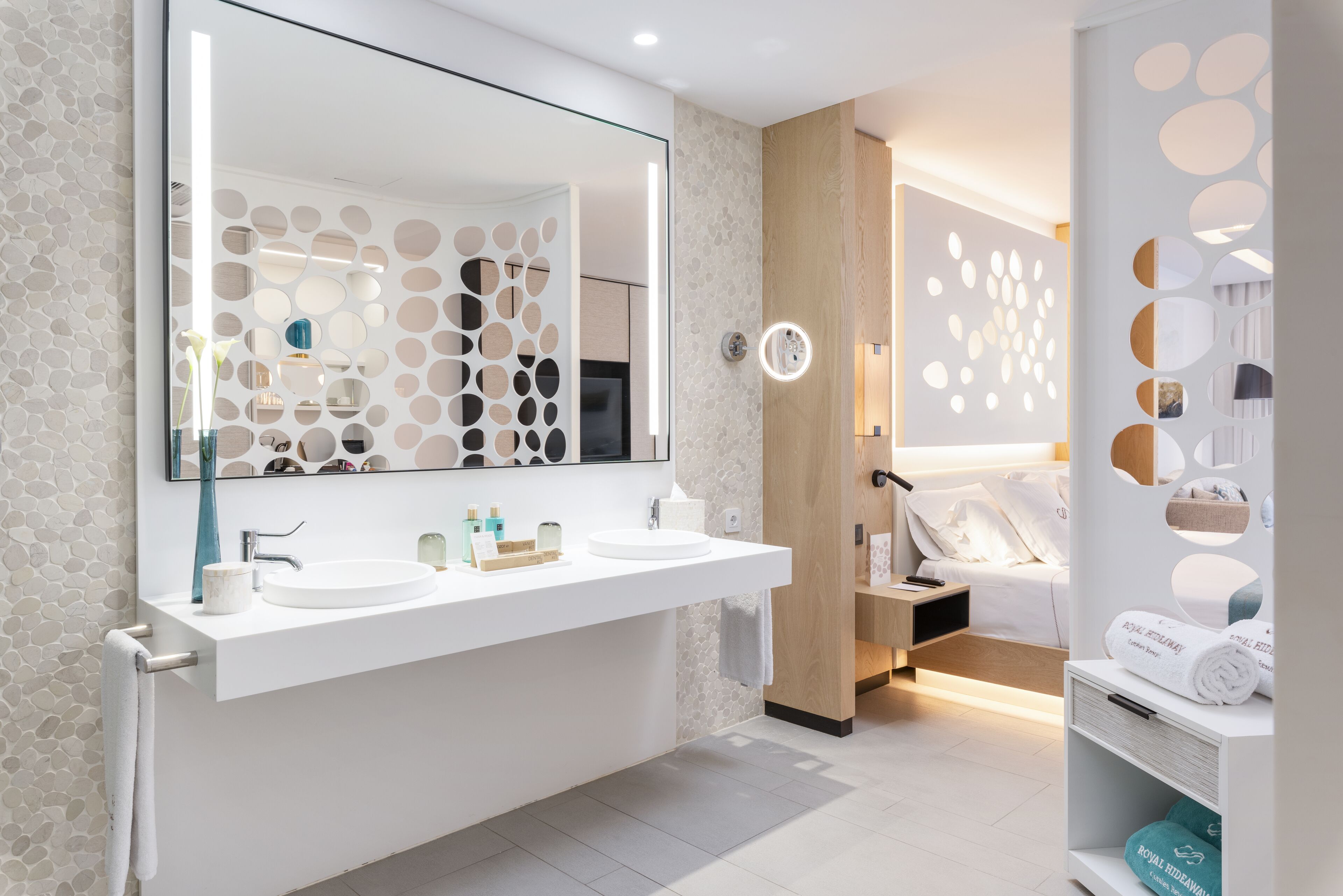 Un baño moderno con dos lavamanos, un espejo grande y una zona de ducha.