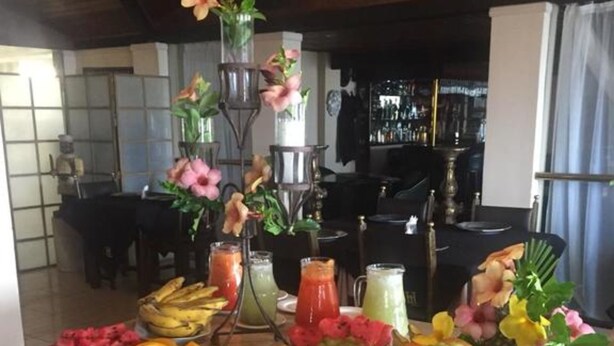 A buffet table with various fruits, vegetables, and a salad.