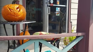 Une devanture de magasin avec une enseigne indiquant « THE LOCAL » et une décoration d’Halloween représentant une citrouille.