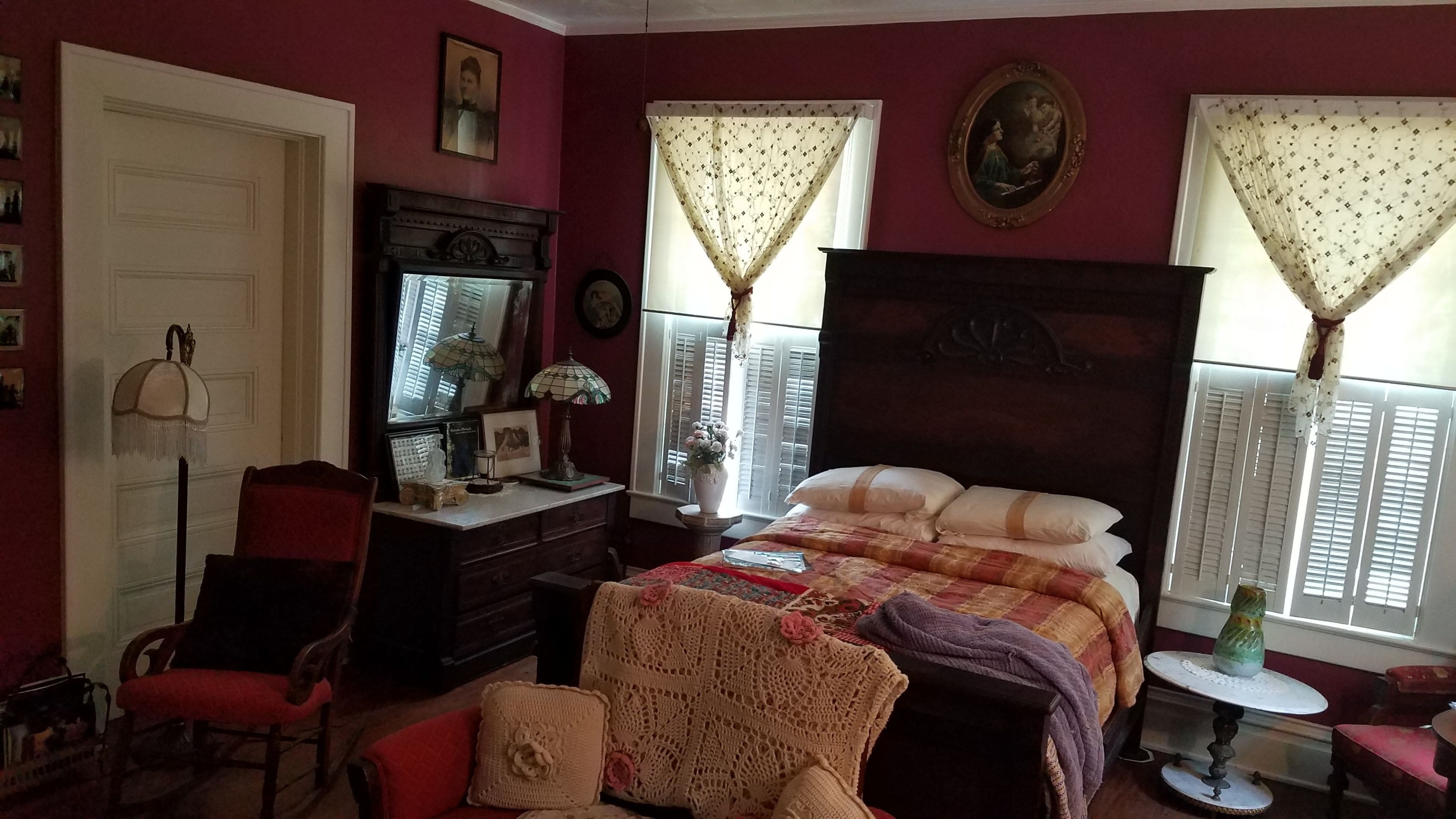 Un dormitorio con una cama grande, un aparador, una silla y una mesita.