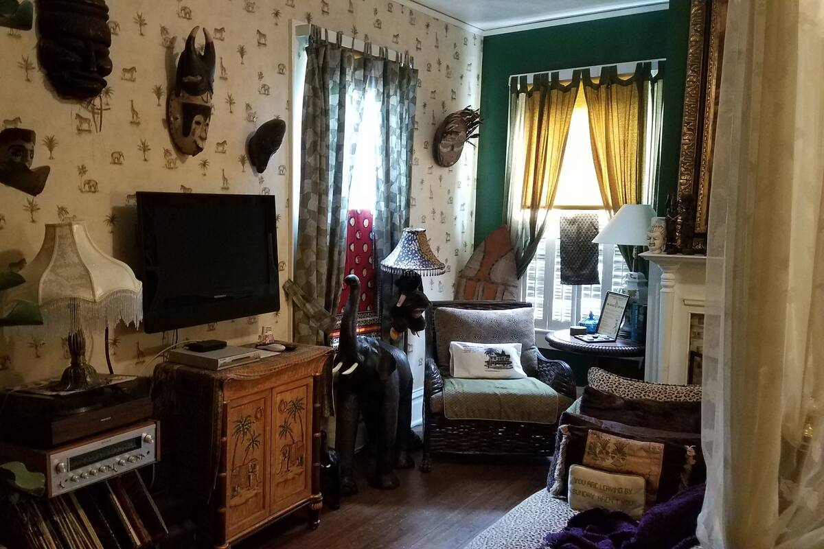 A living room with a television, decorative wall art, a sofa, and a lamp.