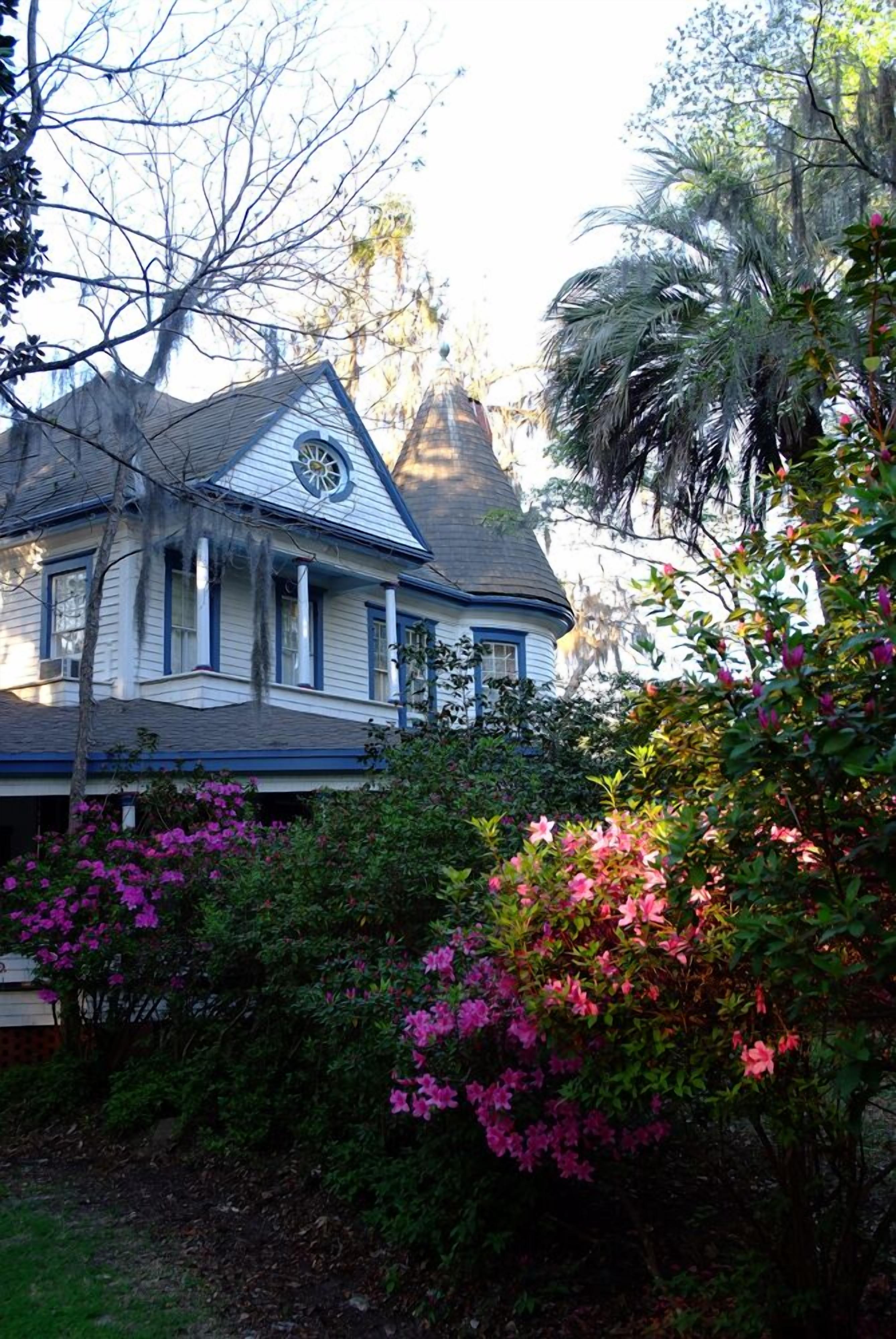 Una casa grande con una aguja distintiva y un ventanal circular.