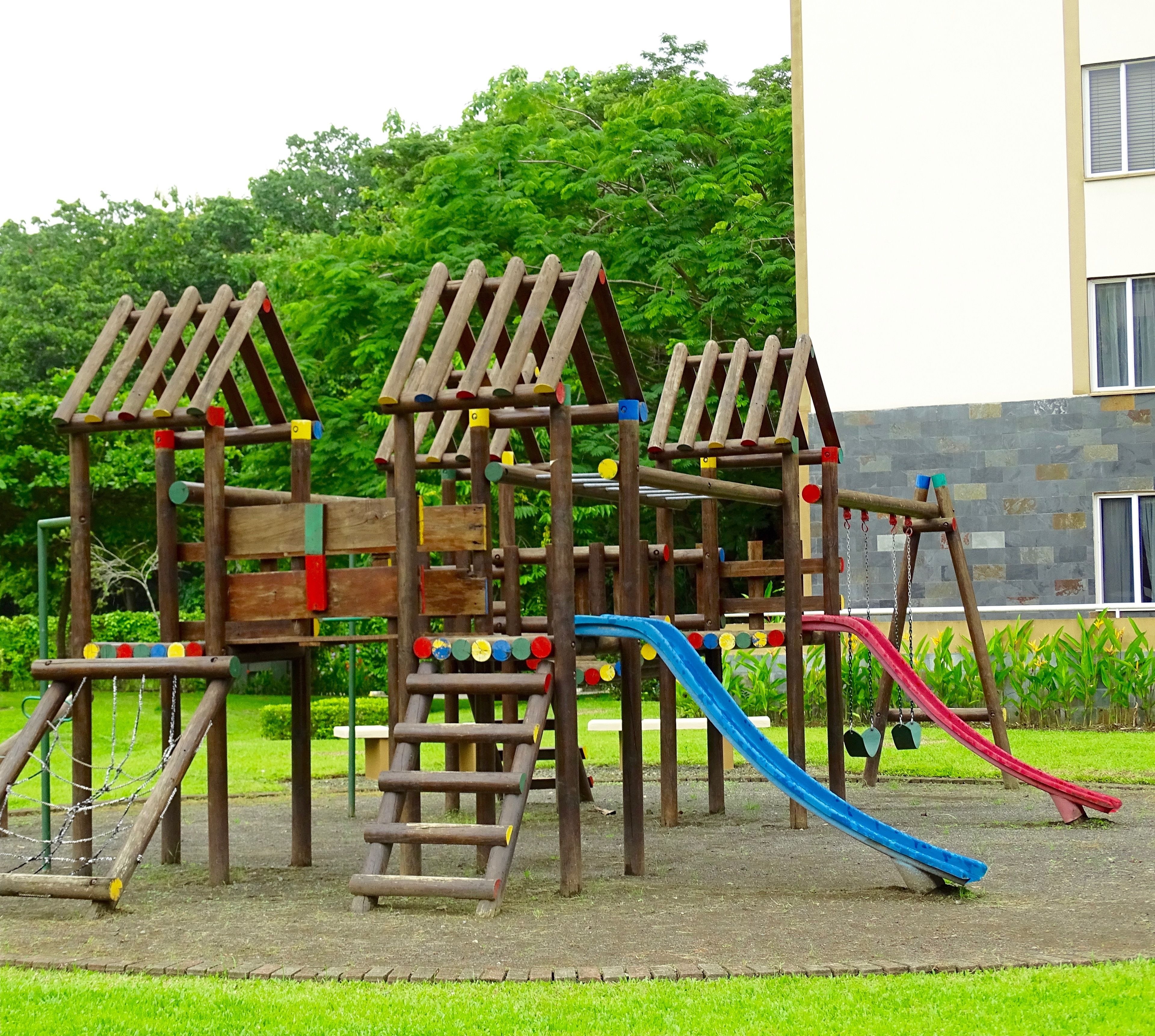 Une structure de jeux en bois, dotée de toboggans et d’éléments d’escalade.