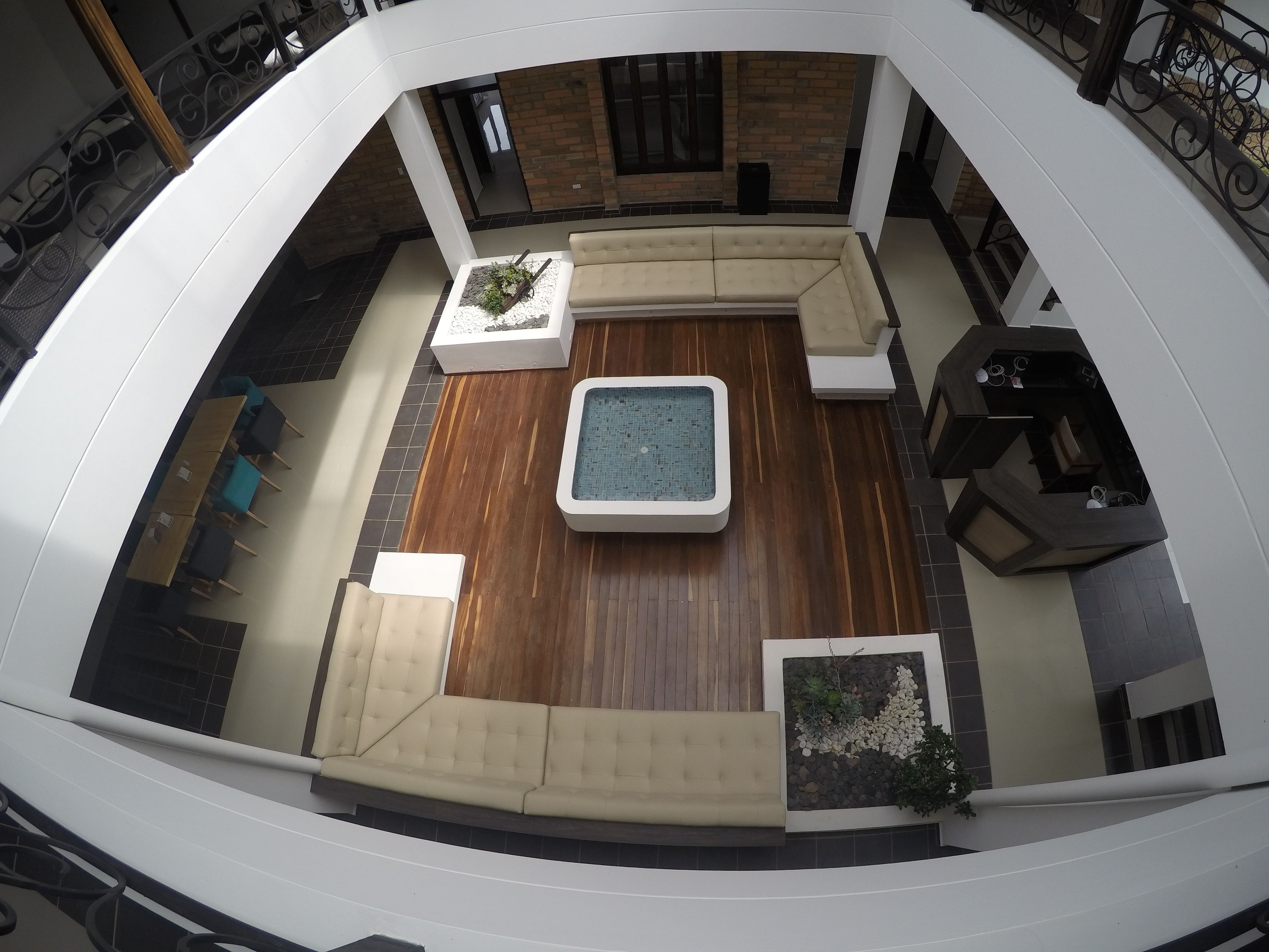 A rooftop terrace with a pool, seating areas, and a wooden floor.