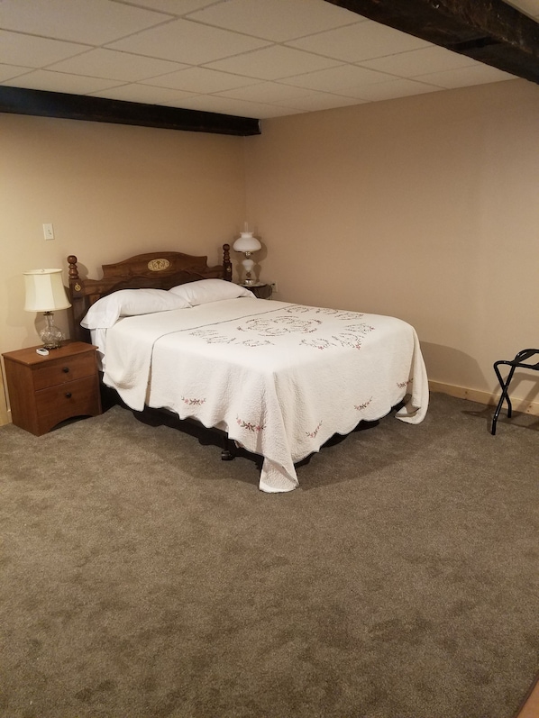 A bedroom with a double bed, two bedside tables, a lamp, and a chair. - Beagle's Bed & Breakfast (Paxinos)