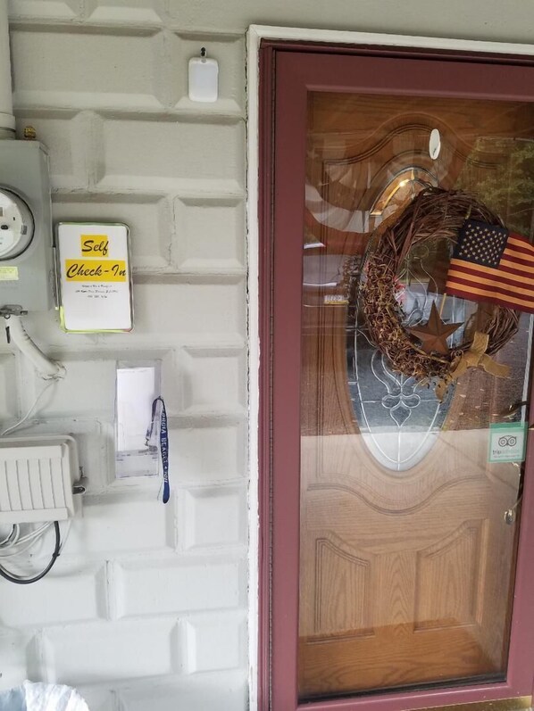 A door with a wooden panel and a glass panel. There is a wreath with an American flag on the glass panel. - Beagle's Bed & Breakfast (Paxinos)