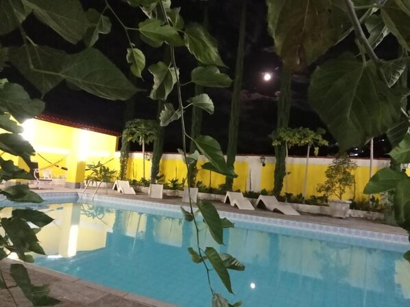 Alberca al aire libre y camastros 