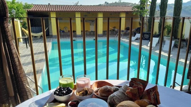 Una mesa de comedor con diversos alimentos y vista a una piscina.