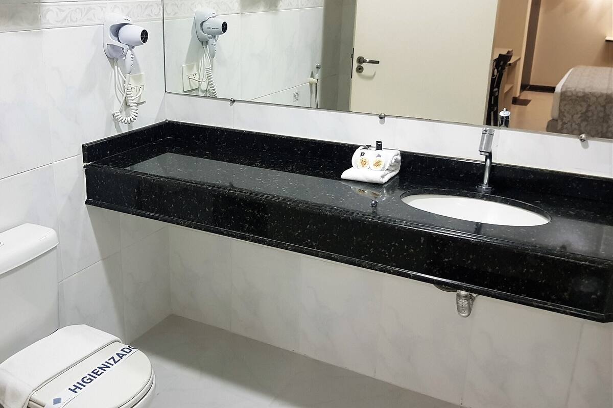 A bathroom with a toilet, sink, and towel rack.