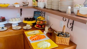 Un bufé con diferentes opciones de comida, incluyendo frutas, pasteles y postres.