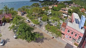 Un pueblo costero con edificios, coches aparcados y vistas al mar.