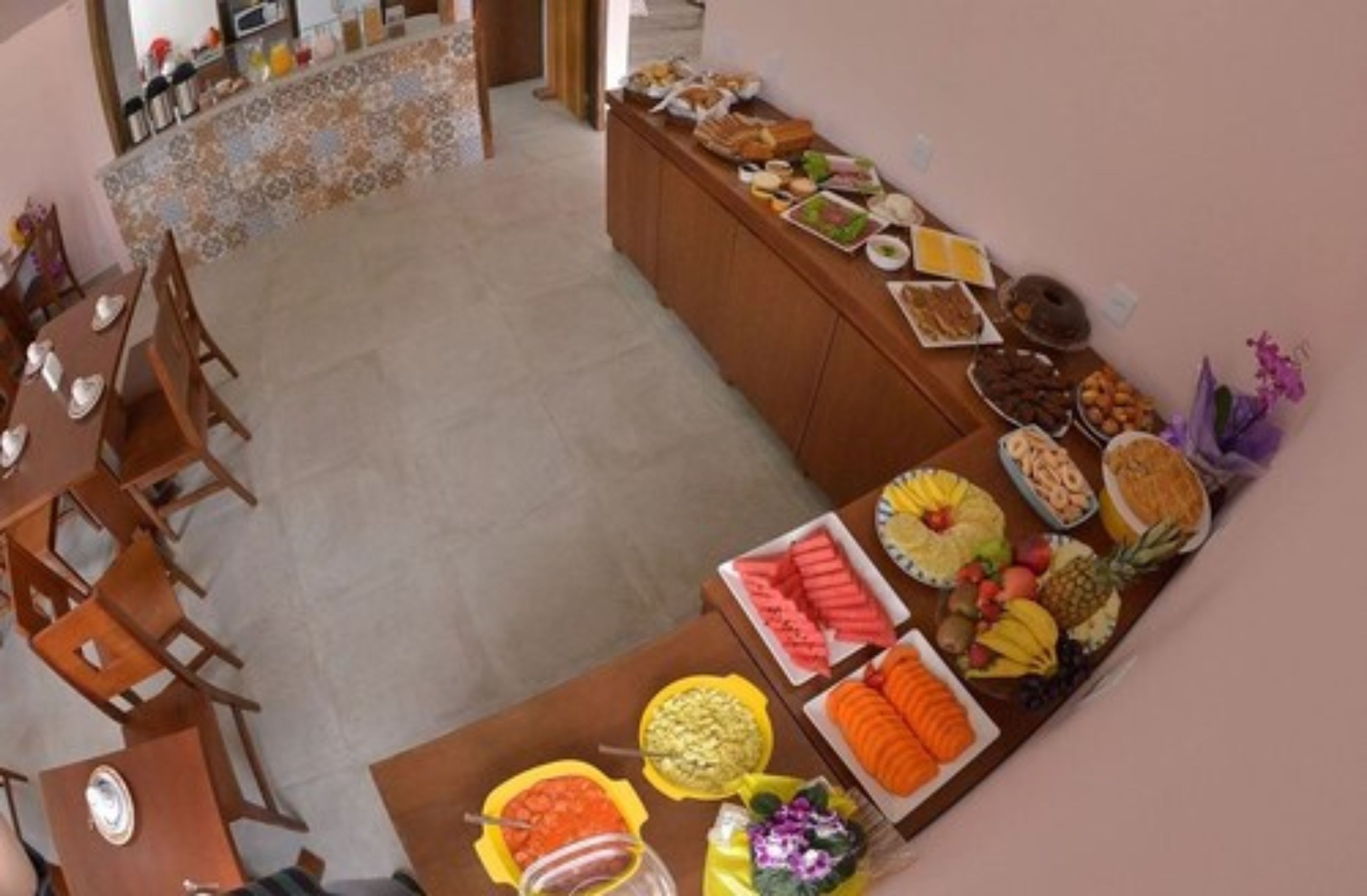 Un espace repas avec un buffet proposant divers plats et un sol carrelé.