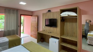 Habitación de hotel con dos camas, televisión, un refrigerador pequeño y un armario de madera.