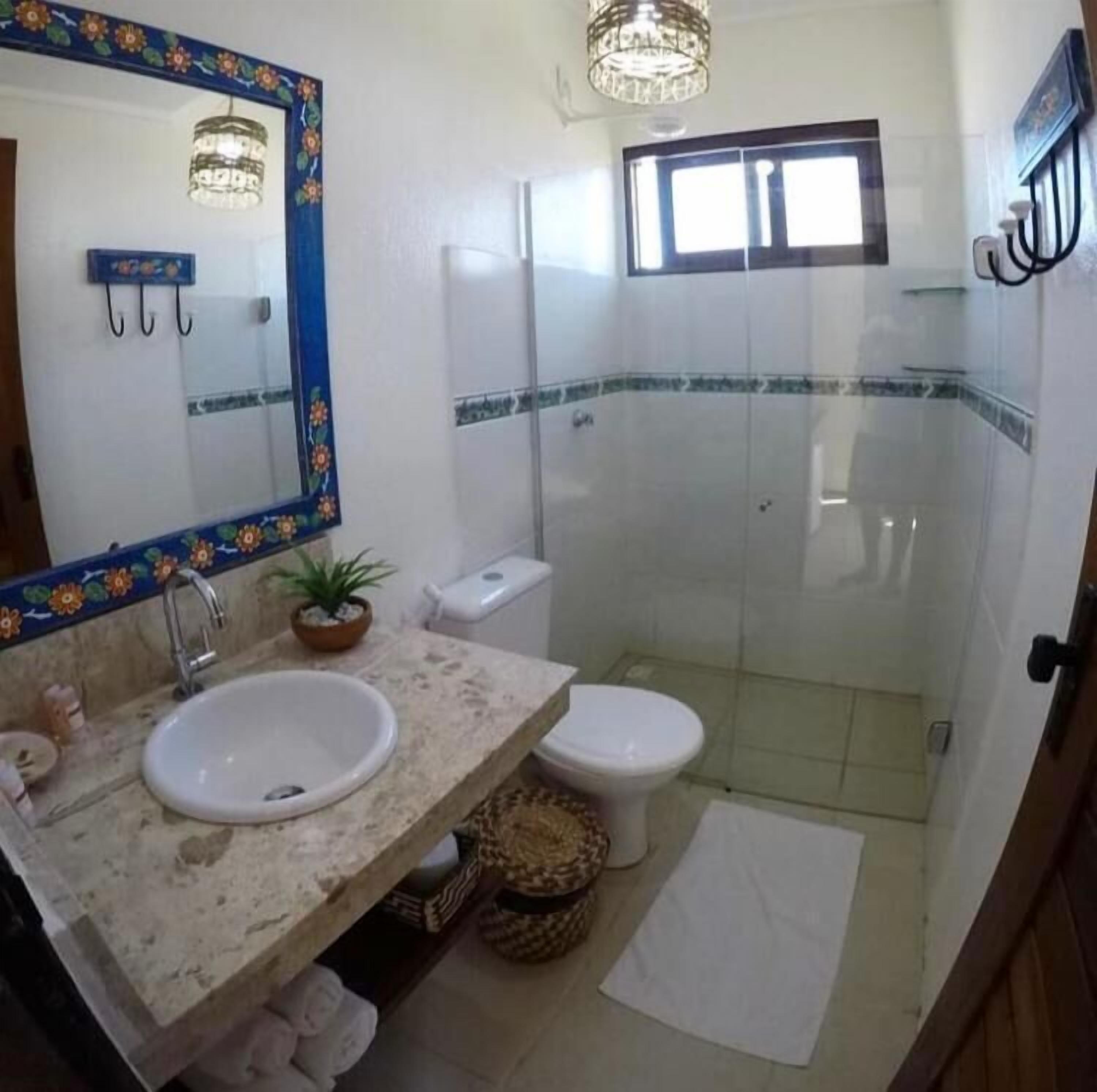 Un baño con lavamanos, inodoro y ducha.
