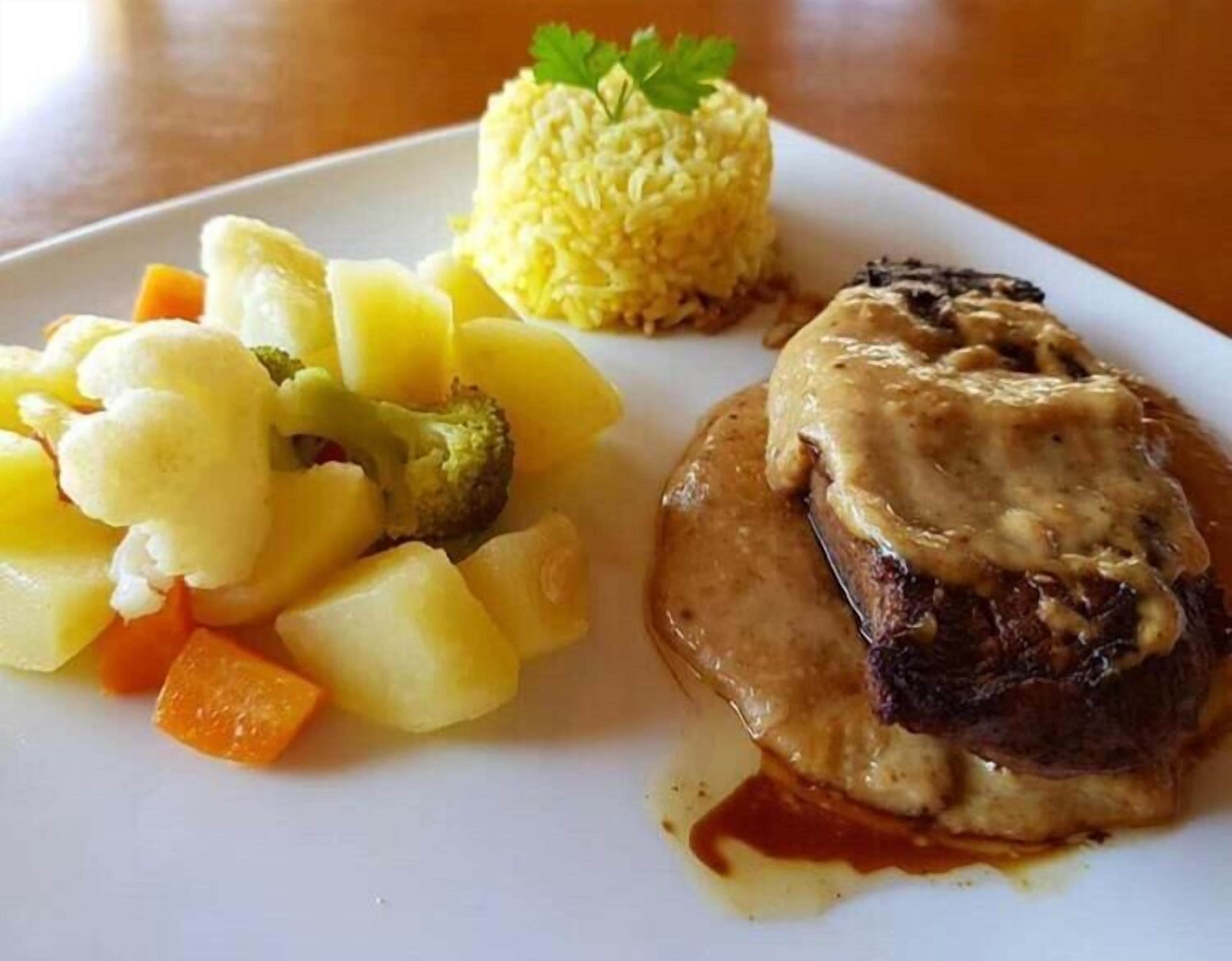 A plate with a meat dish, mashed potatoes, and steamed vegetables.