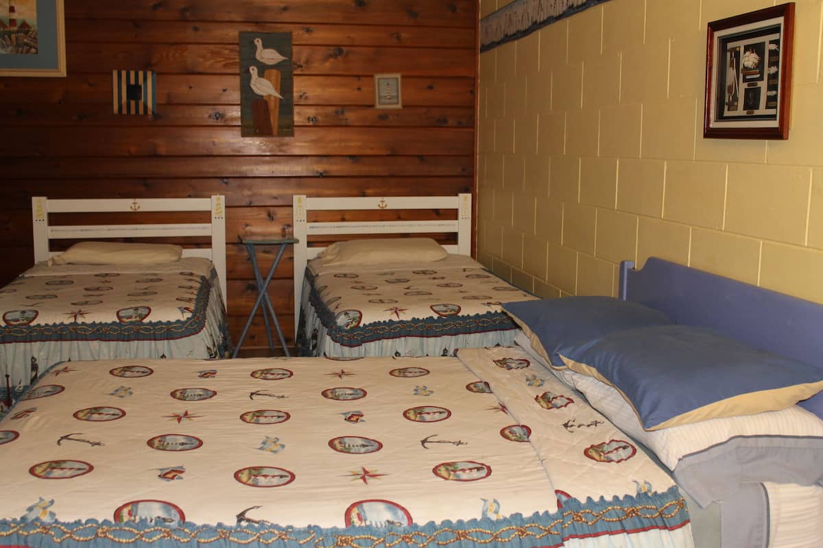 A room with two beds, each with a matching headboard and footboard, and a single bed with a blue headboard.