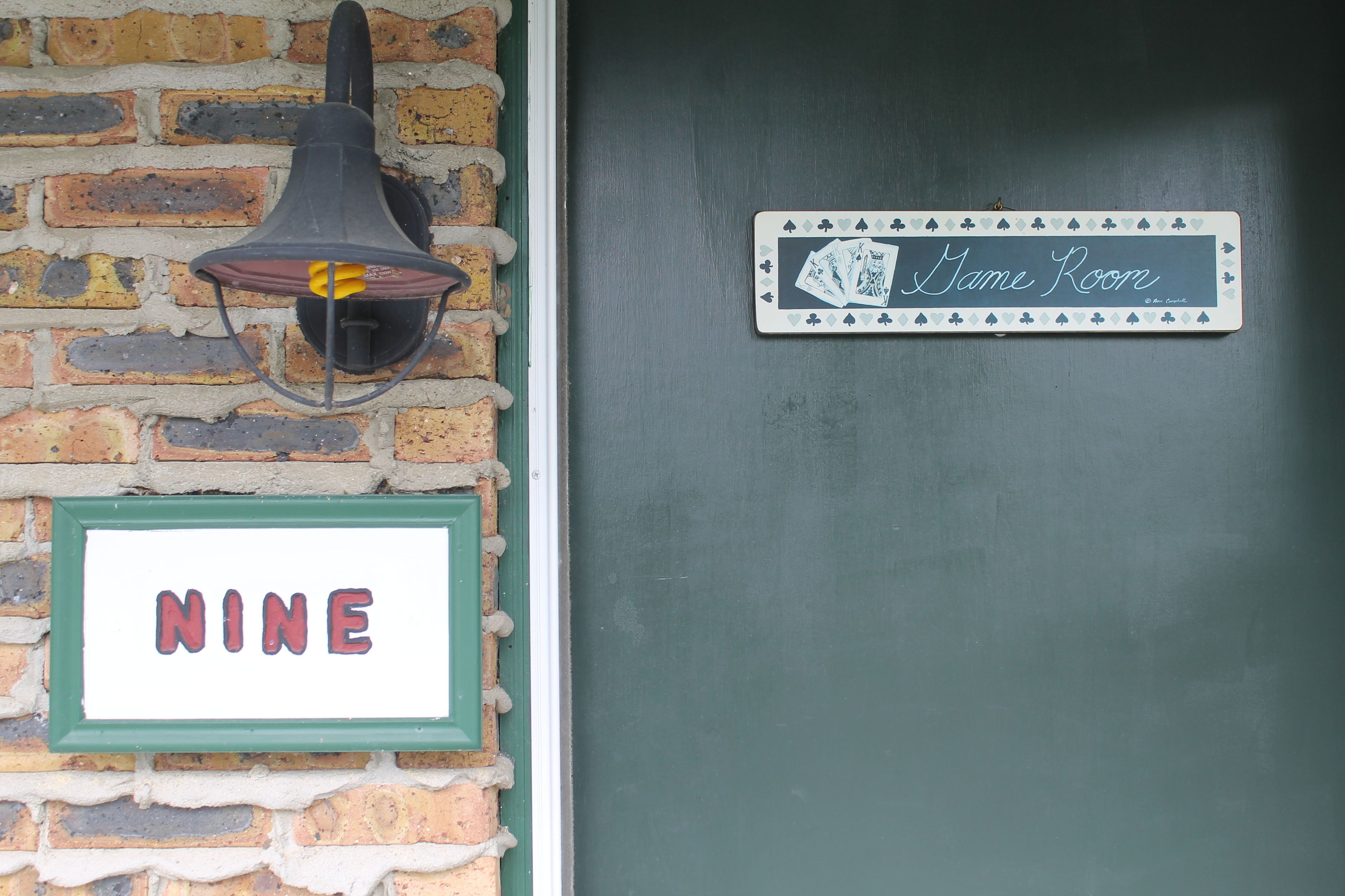 Una porta amb un rètol que diu 'Nine' i un altre que indica 'Dame Room'.