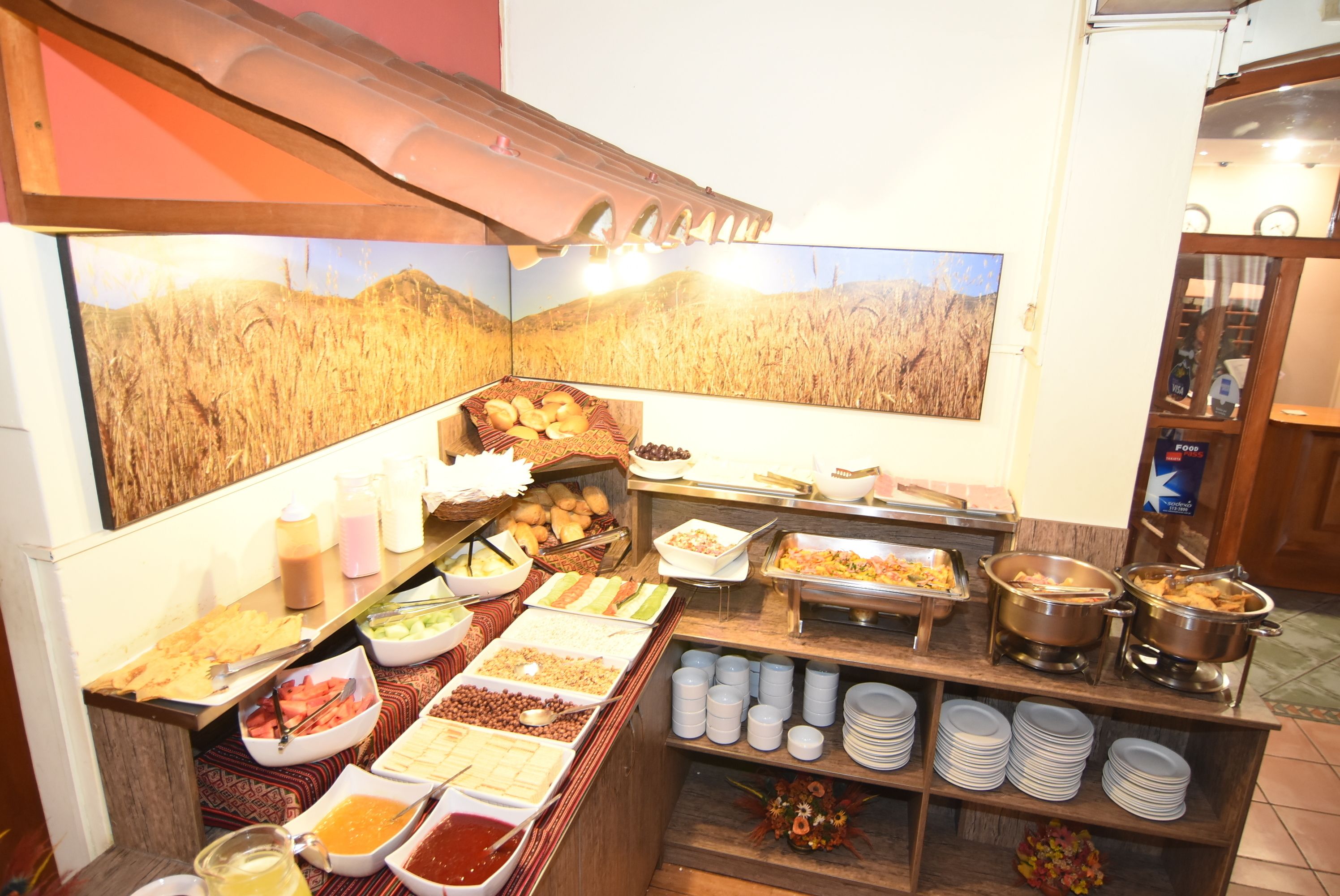 Un buffet con diverse pietanze e bevande, tra cui zuppe, frutta e dolci.