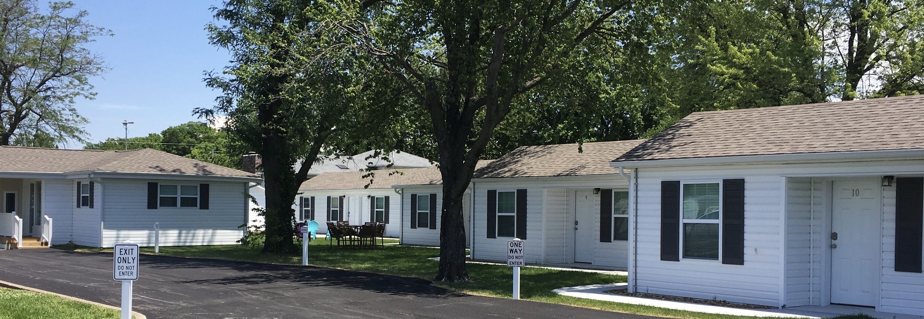 A row of single-story mobile homes with a clear driveway and a 'DO NOT ENTER' sign visible.