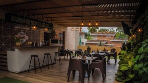 An indoor restaurant with a bar area, wooden flooring, and several tables and chairs. - Hotel Lomas 10 (Medellín)