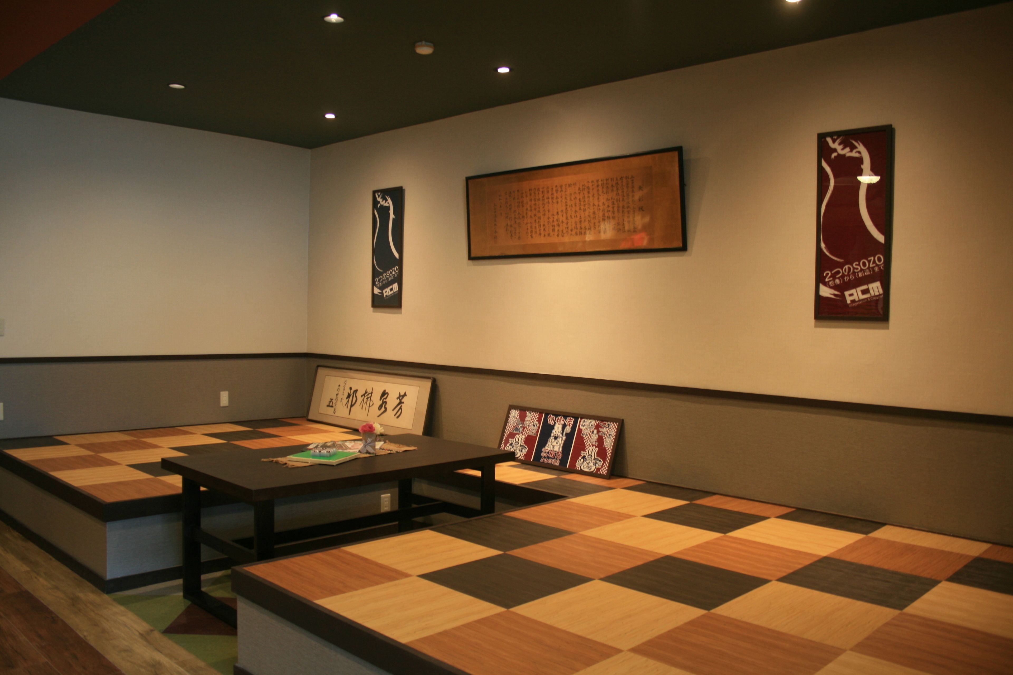 A room with a checkered floor, a table, and several framed items on the wall.
