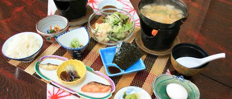 Una mesa con diversos platos, incluyendo arroz, sopa y verduras, indicando un ambiente de comida.