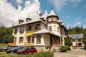 A large, multi-story building with a traditional architectural style, featuring a prominent tower and multiple balconies.
